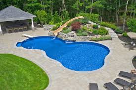 Backyard pool with waterslide and surrounding garden.