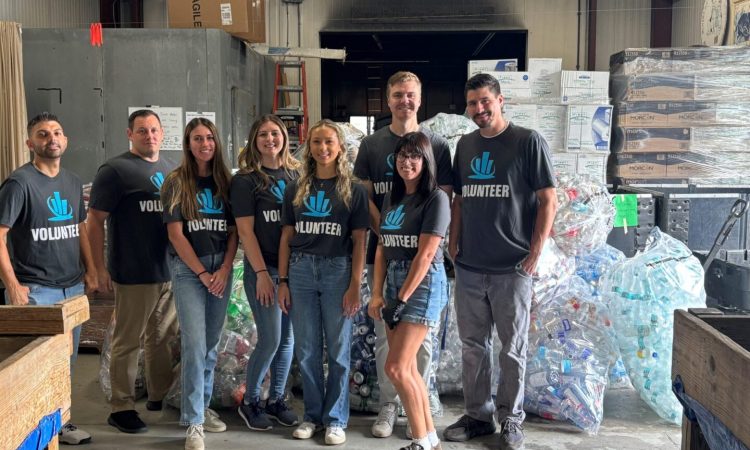 Eight volunteers standing by bags of recyclables